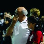 man in white shirt crying in crowd with arm around younger girl in red