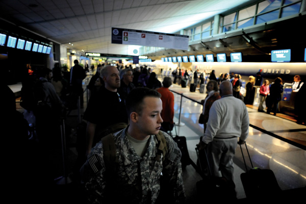 His leave over, Ian Fisher waits in line at the Denver airport