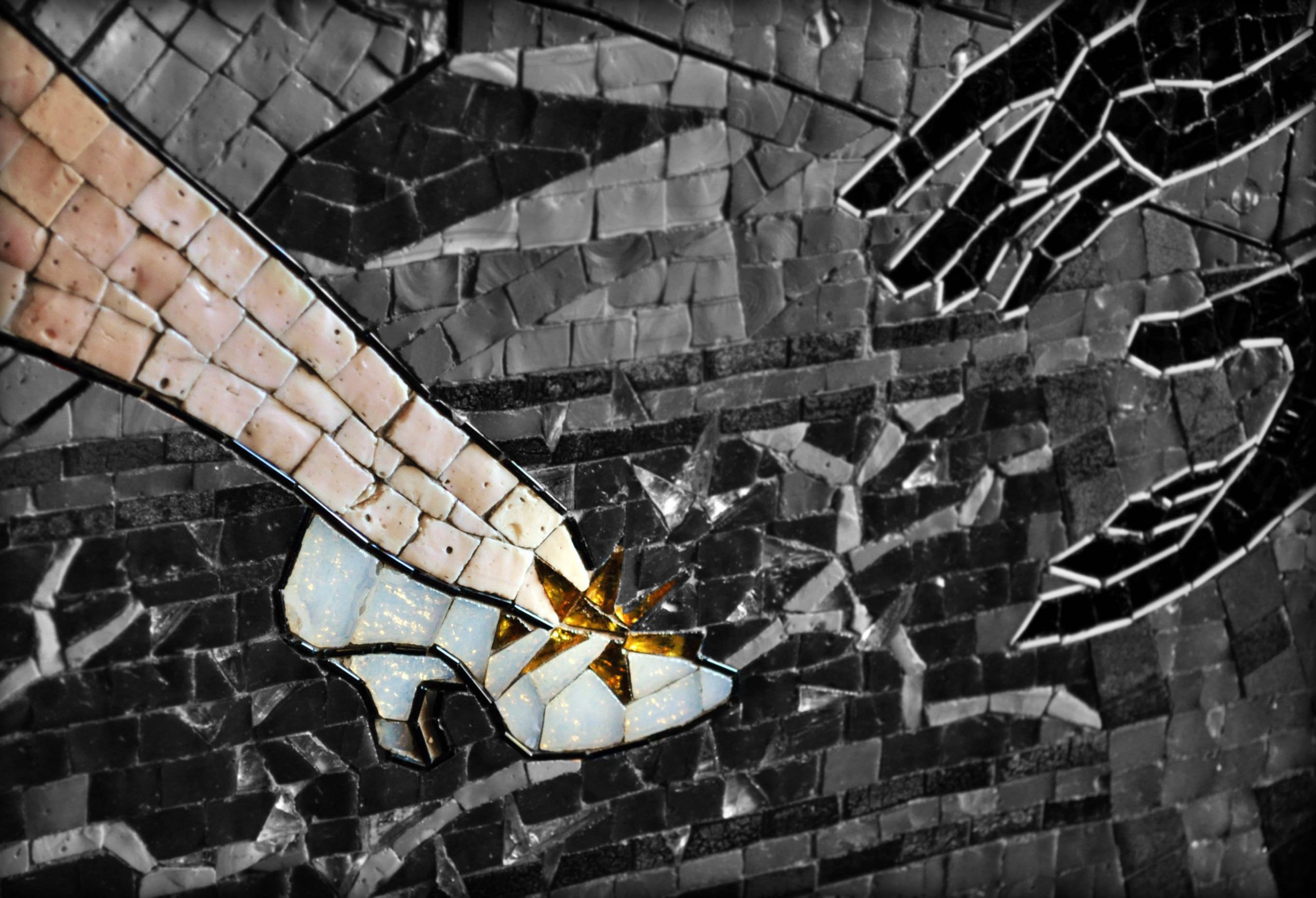 mosaic wall depicting hands reaching towards Cinderella's foot which is adorned by a glass slipper with a gold star atop it