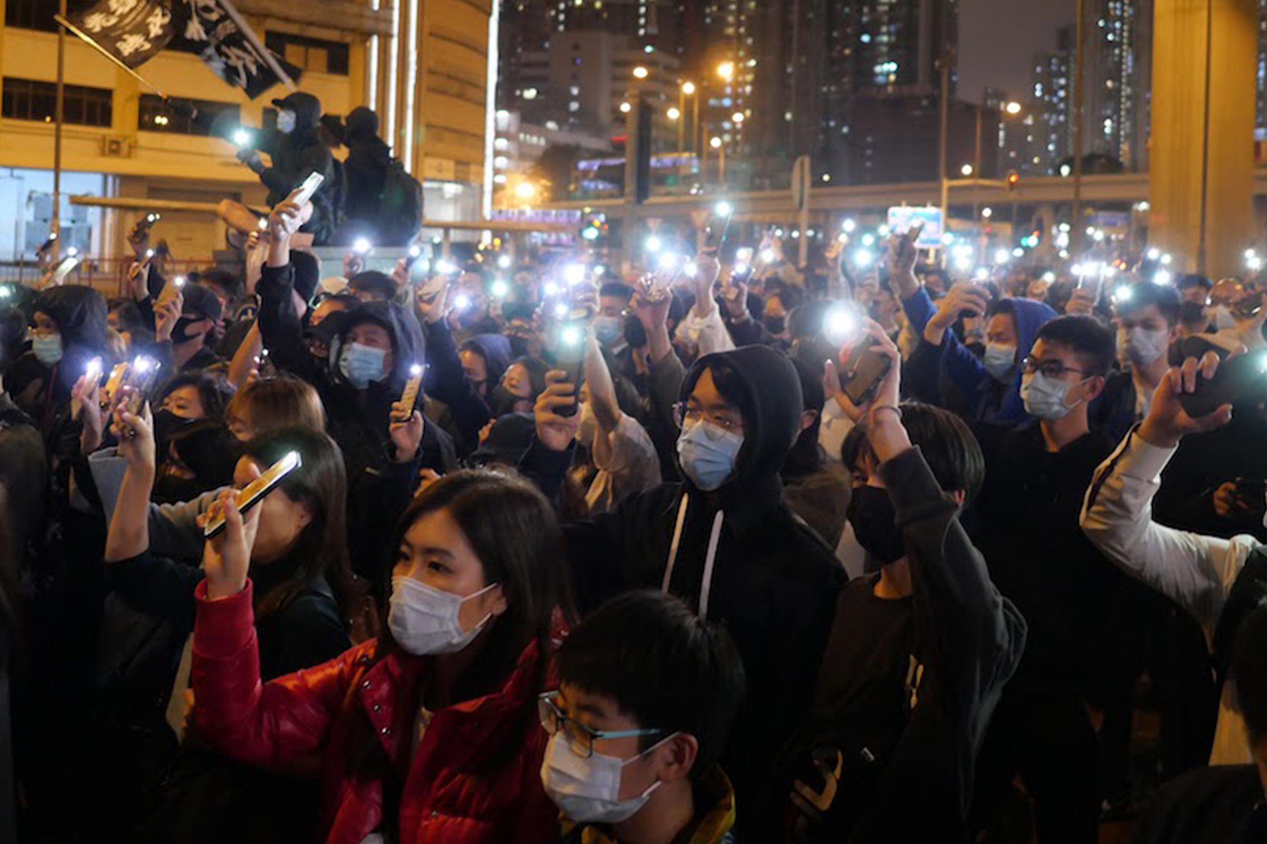 protesters holding up phones as flashlights