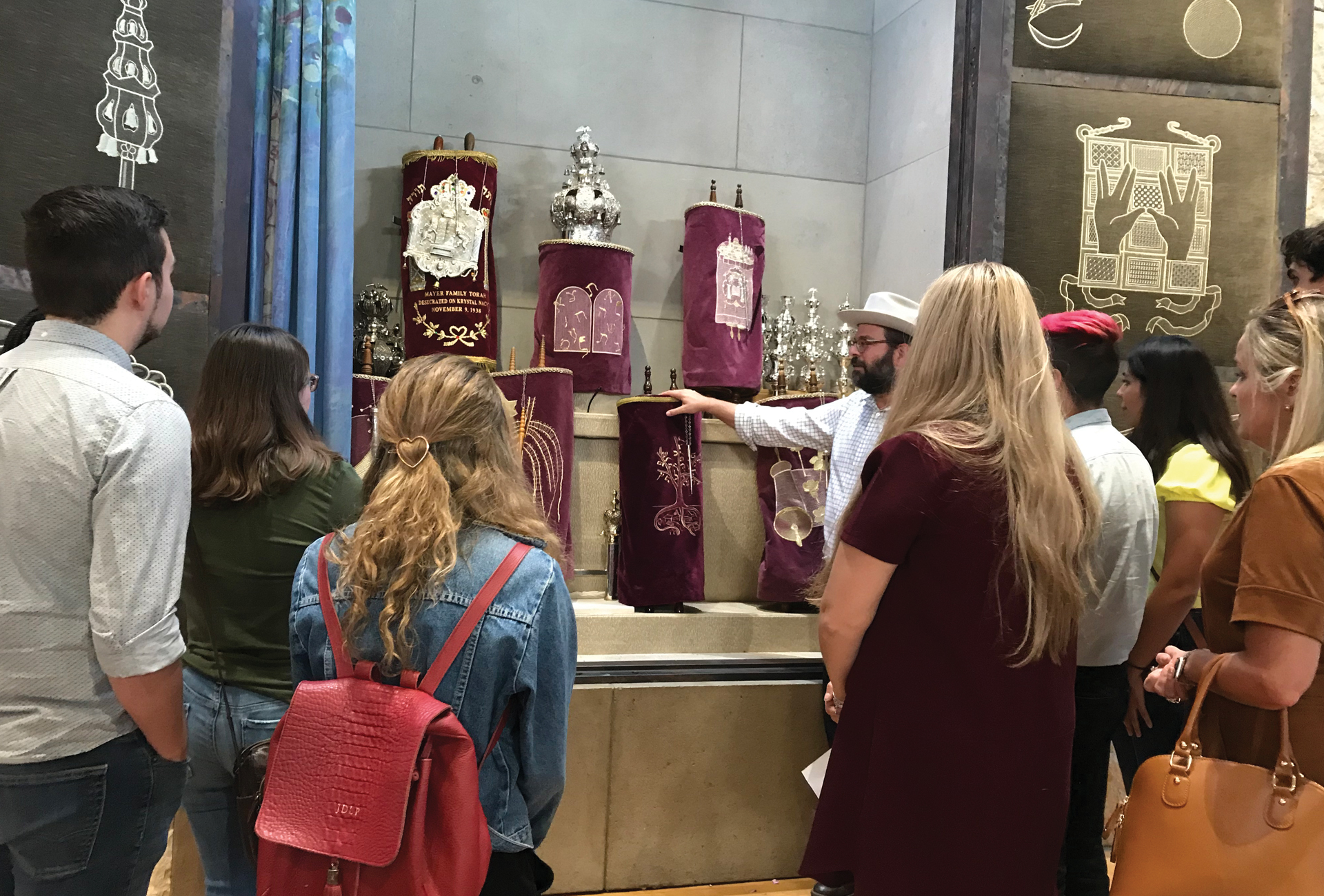 A group gathered around a collection of royal crowns and artifacts